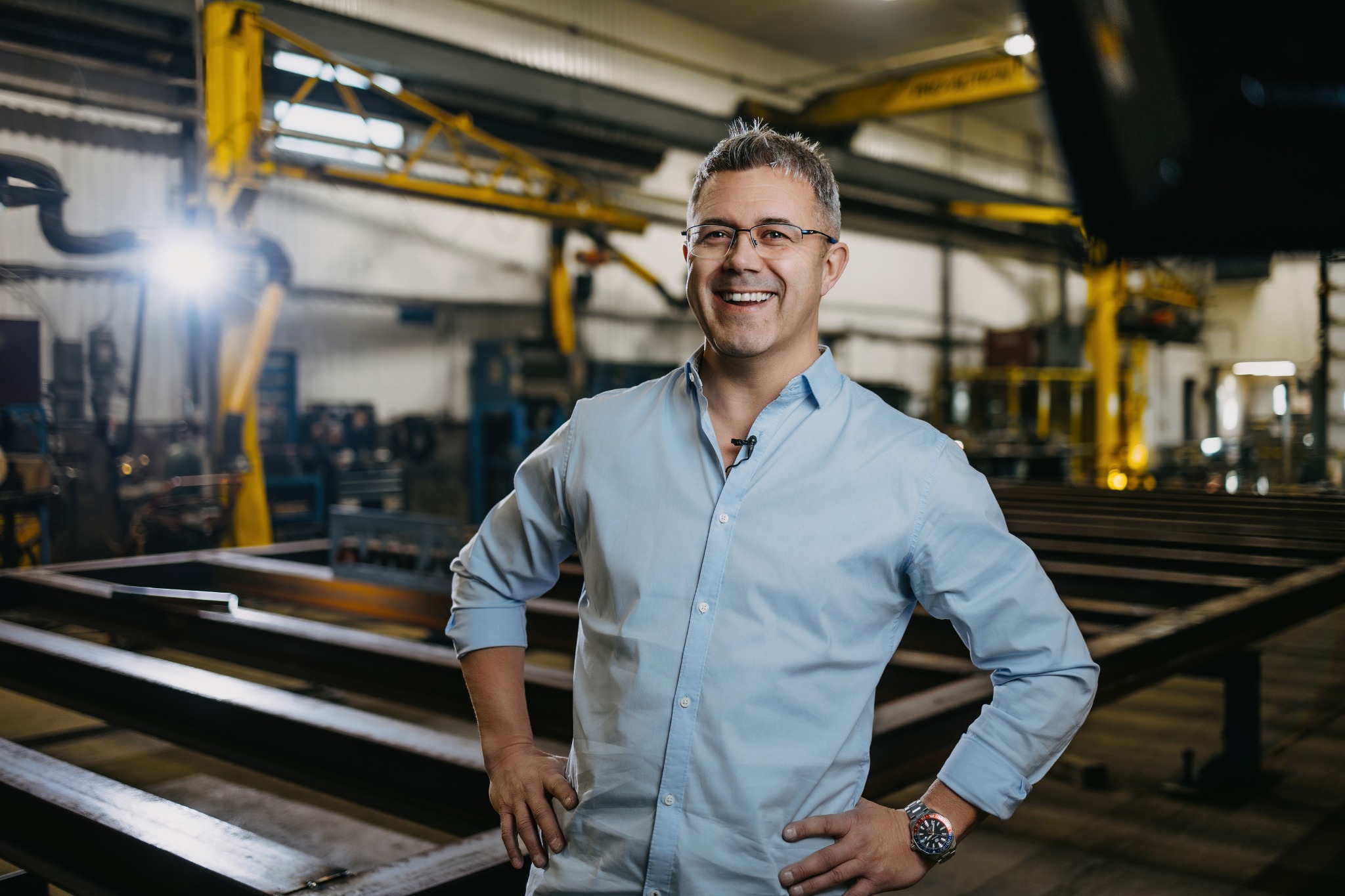Martin Lépine, en chemise claire, debout dans un atelier industriel.