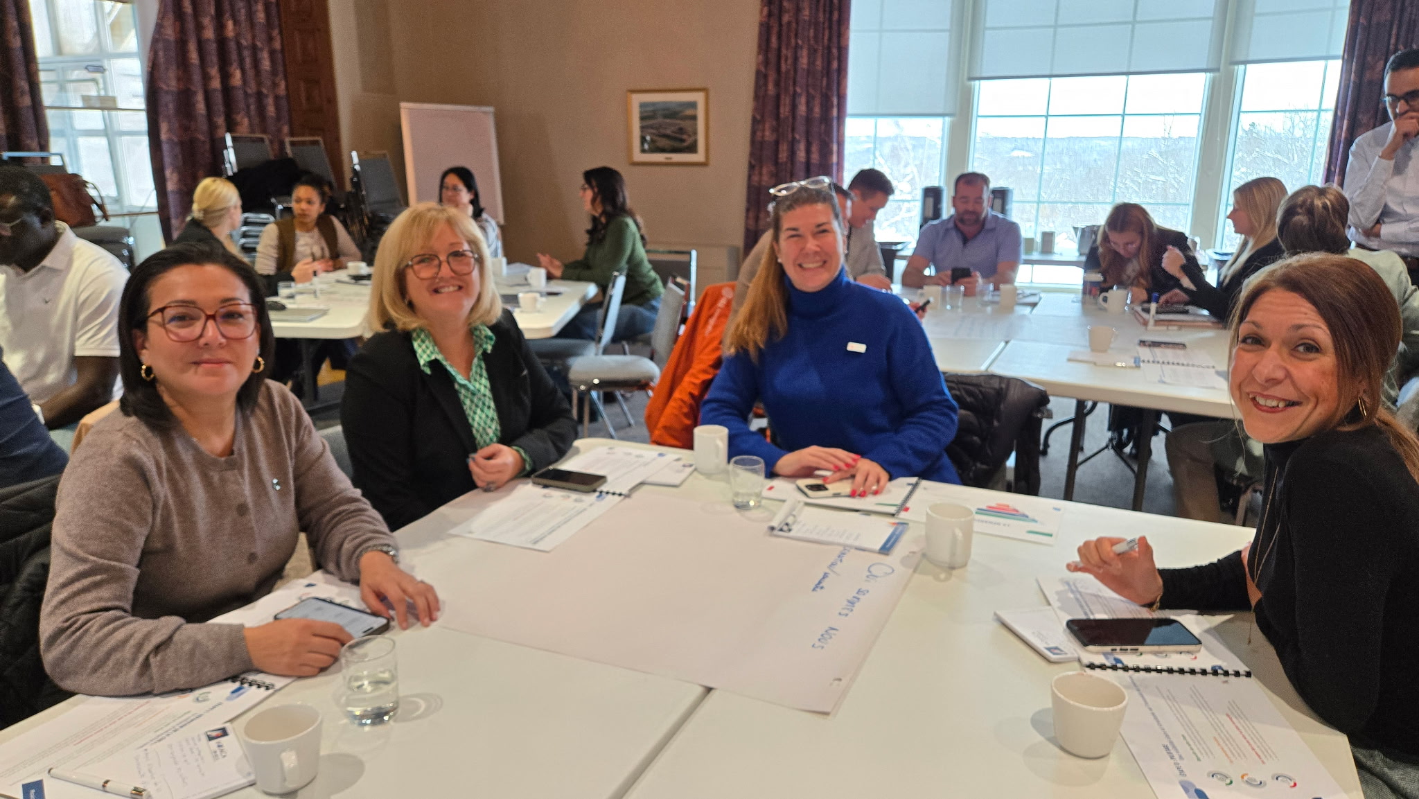 Quatre participantes souriantes autour de la table lors d'une Table Ronde Régionale au Manoir du Saguenay